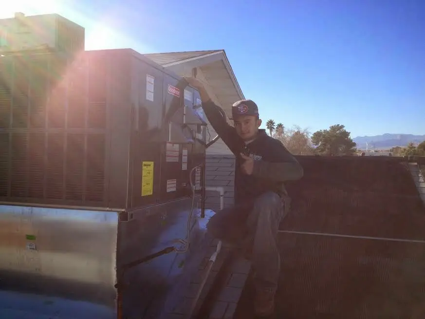 HVAC technician performing Air Duct Repair on a rooftop unit in Newport